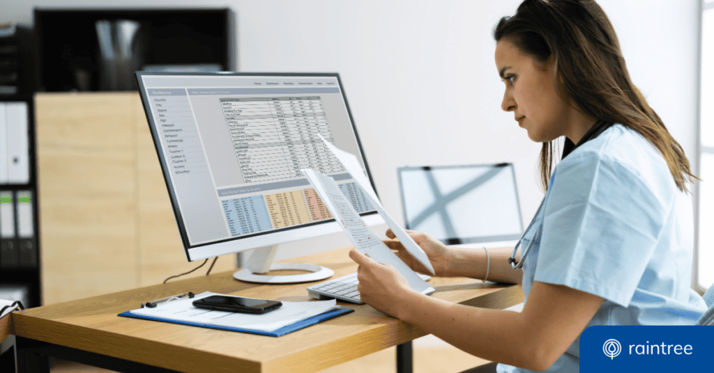 Someone wearing blue scrubs looks at a computer and printed documents. Illustrating the topic: "Clinical Documentation Best Practices."