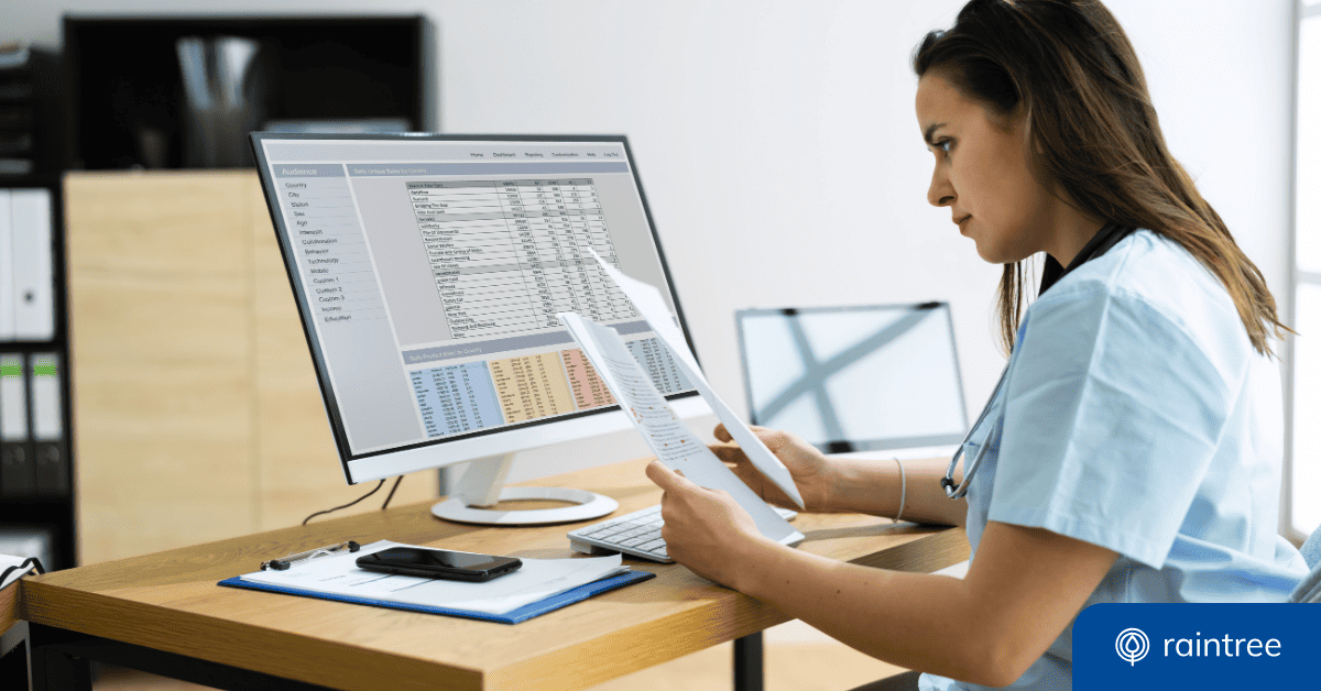 Someone Wearing Blue Scrubs Looks At A Computer And Printed Documents. Illustrating The Topic: &Quot;Clinical Documentation Best Practices.&Quot;