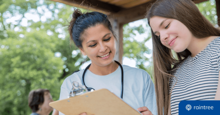 A physical therapist talks to a teenager at a community health fair volunteer event. Illustrating the topic: "Physical Therapy Day of Service."
