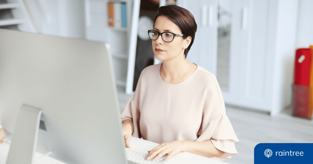 A practice admin looks at their desktop computer. Illustrating the benefits of EHR and EMR technology.