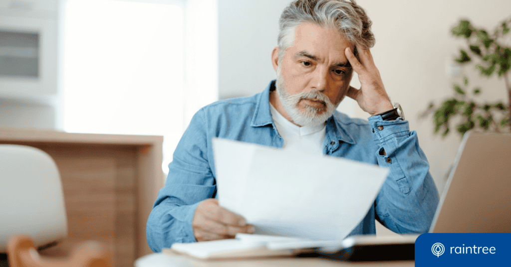 A patient with short gray hair reacts with concern while looking at a medical bill. Illustrating the importance of the No Surprises Act.