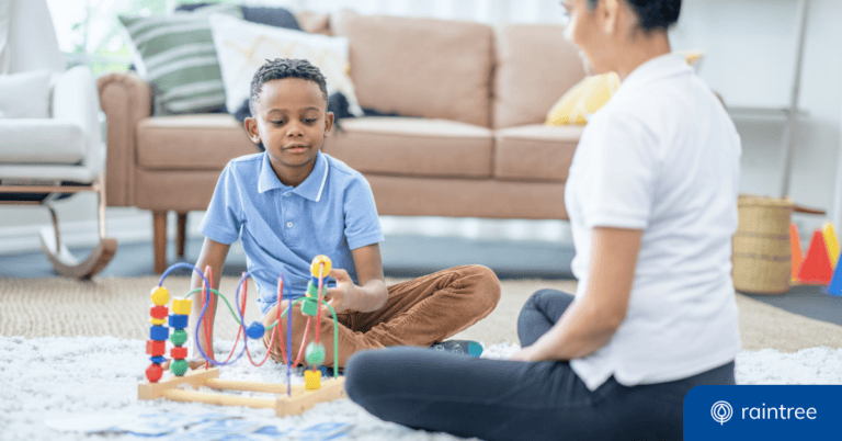 A BCBA works with an autistic child who plays with a toy. Illustrating the topic of choosing an EMR for Applied Behavior Analysis (ABA).