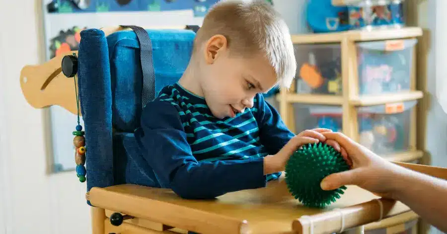 Header image depicting a child in a chair during pediatric therapy, touching a sensory ball. The heading reads: "Multi-sensory Environments in Occupational Therapy"
