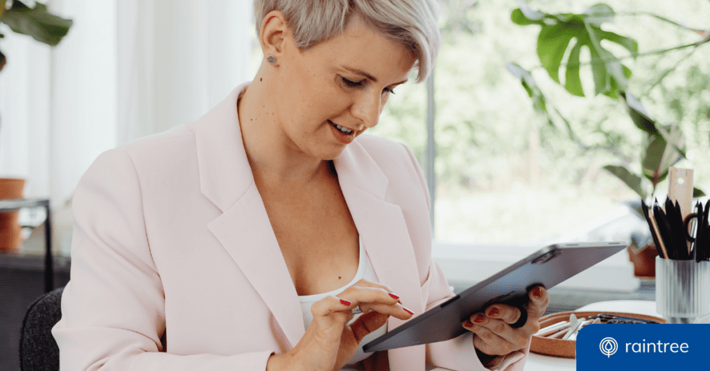 A person with short blonde hair and a pink blazer looks down at a tablet, illustrating the concept of introducing new technology in physical therapy.