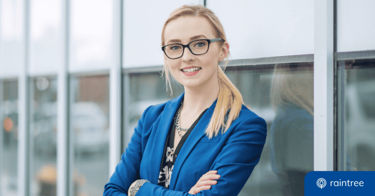 A young professional with dark glasses and a blue blazer looks at the camera and smiles. Illustrating the topic: "When Should I Join the APTA?"