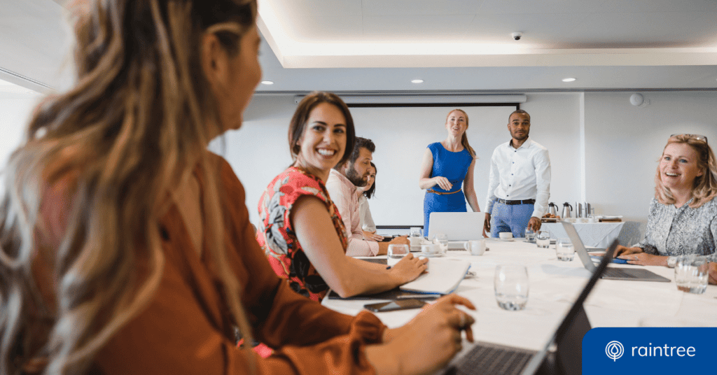 A group of rehabilitation therapy professionals sit and stand at a meeting desk, looking at someone in the foreground. Illustrating the topic of rehabilitation and physical therapy advocacy campaigns and opportunities.