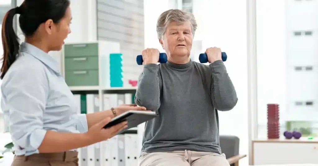 A physical therapist wearing a headset looks down at a computer monitor. Illustrating the topic: "What is Certified EHR Technology (CEHRT) and why is it important for rehab therapy?"