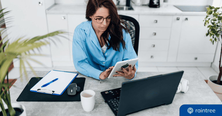 A social media strategist holds a tablet while sitting at a desk in a physical therapy clinic. Illustrating the topic: "Social Media Calendar Planning for Rehab Therapy Practices"