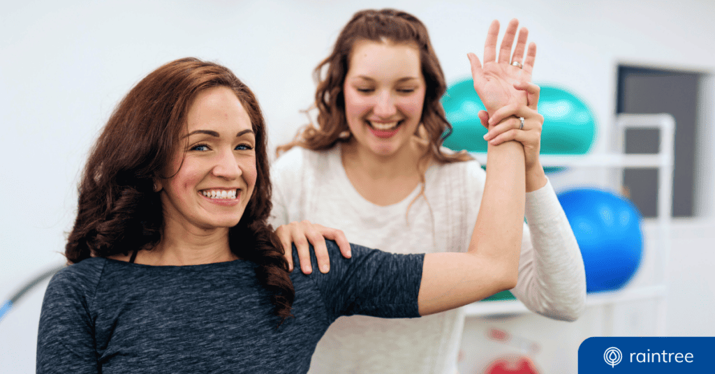 A Physical Therapist Works With A Happy Patient, Who Is Holding Her Arm Up At A Right Angle. Illustrating The Topic: &Quot;How To Increase Patient Referrals To Your Physical Therapy Practice.&Quot;