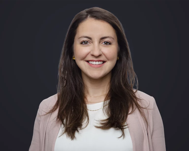 Sarina Headshot On Dark Blue Background