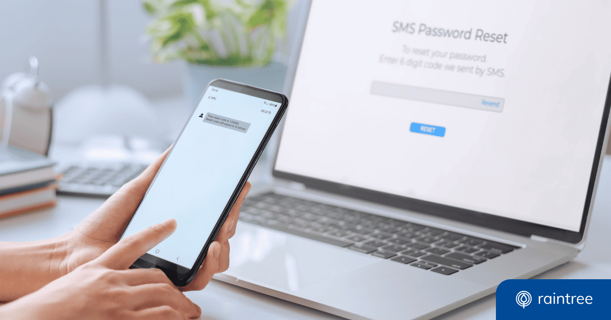 Someone holds up a phone in front of a laptop, while completing a two-factor authentication process to reset a password. Illustrating the topic of "Creating a Stronger Cybersecurity Posture in Healthcare"