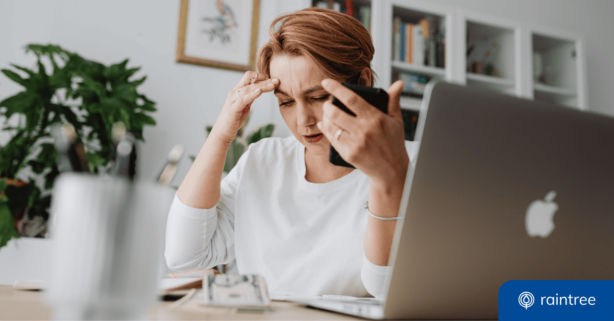 A Professional Sits At A Desk With A Laptop In The Foreground, Holding A Phone And Touching Their Forehead, With A Furrowed Brow. Illustrating The Topic Of Phishing As A Top Threat To Health Data Security.