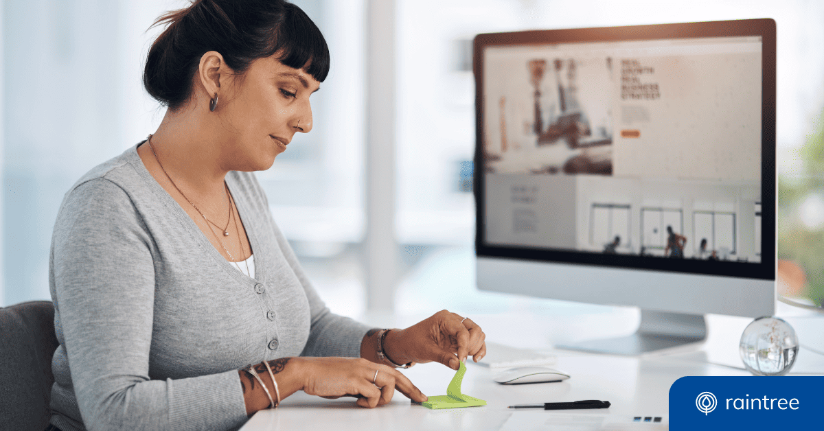 A medical biller with dark hair and bangs looks down at a sticky note pad, while sitting at a desk. Illustrating the topic, "What is the Medicare 8-minute rule?"