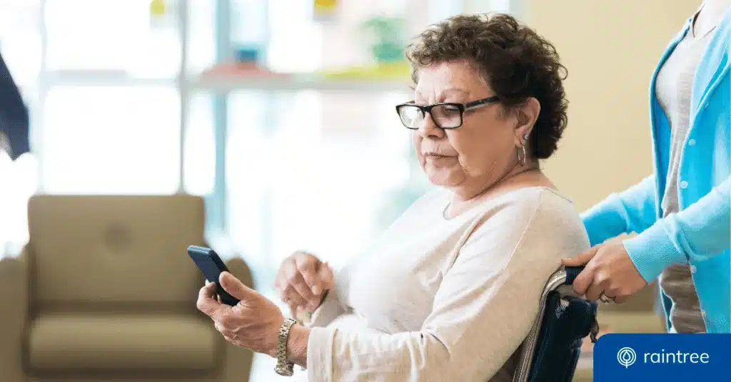 A Medicare Patient Looks At Her Phone While A Physical Therapist Pushes Her Wheelchair. She Has A Concerned Expression. Illustrating The Topic Of Billing Mistakes And The Importance Of Claim Scrubbing.