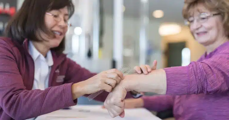 Occupational therapist working with senior woman on hand therapy, illustrating the topic of "cpt codes for occupational therapy."