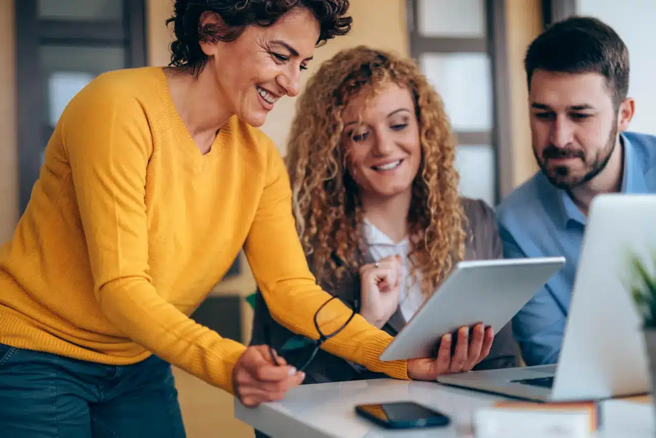 Photo Of Private Practice Owners Using A Tablet And Laptop In A Business Setting, Illustrating Raintree'S Vendor Partnerships.