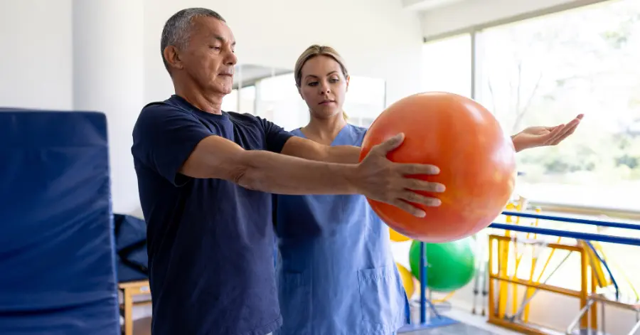 A Physical Therapist Works With A Patient One On One Utilizing An Invisible Emr That Transcribes Notes In Real Time, Illustrating The Raintree User Experience.