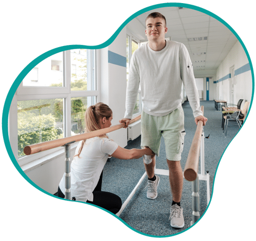Home 4 A Physical Therapy Patient Smiles While Completing A Balance Activity Utilizing Parallel Bars, While A Physical Therapist In A White Polo Shirt Observes.