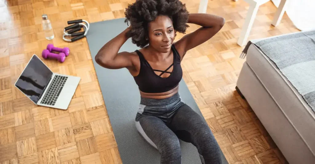 Patient sits on a yoga mat with computer in the background, working on Remote Therapeutic Monitoring program; illustrating the topic of new 2026 RTM Codes for MSK.